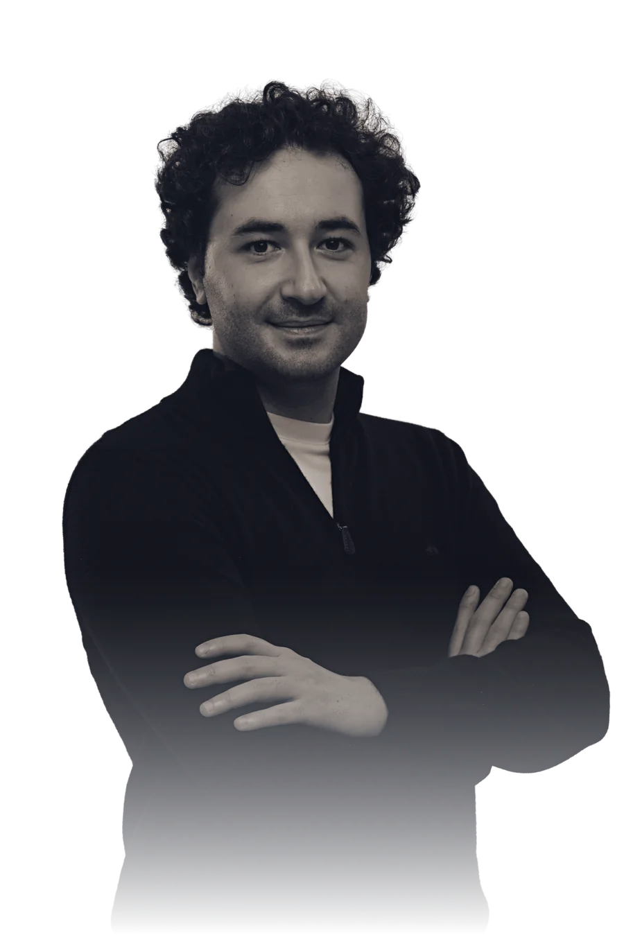 Emre Aydın, founder and director of AVERNOX, photographed against darkness with his arms crossed.